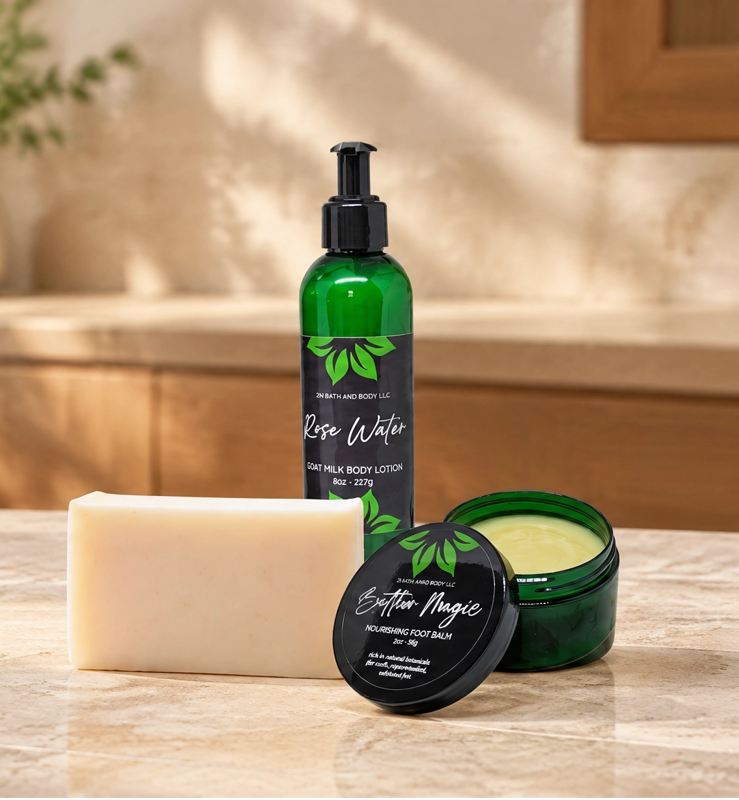 A set of three botanical skincare products from the brand 'Botanical Beauty' arranged on a marble countertop in a warm, sunlit bathroom setting. The products include a green pump bottle of body wash, a green jar of body butter with its lid off, and a solid bar of soap.